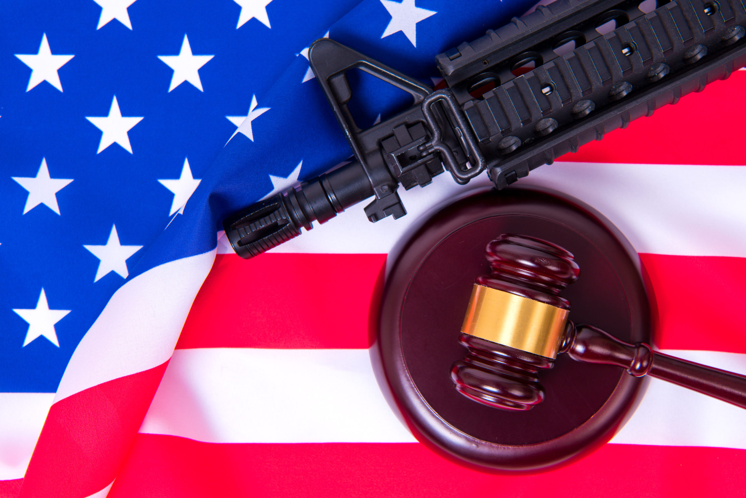Gavel with gun on background of USA flag.
